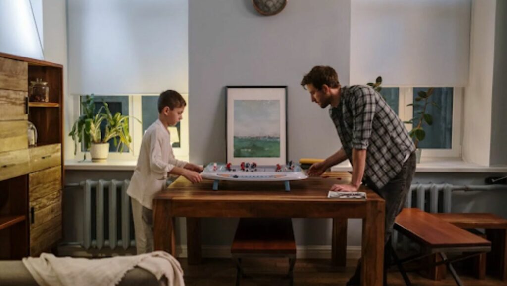 father and son playing a tabletop hockey game